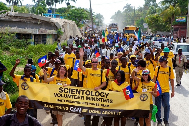 Εθελοντές Λειτουργοί της Σαηεντολογίας από την Αϊτή και άλλες χώρες έκαναν πορεία από το προάστιο Πορτ Ο' Πρινς της Καρφούρ στην πόλη της Λεογκάν για τον εορτασμό της Ημέρας της Σημαίας, εθνική γιορτή στη μνήμη της ανεξαρτησίας της Αϊτής από τα γαλλική καταπίεση και τη δουλεία το 1803.